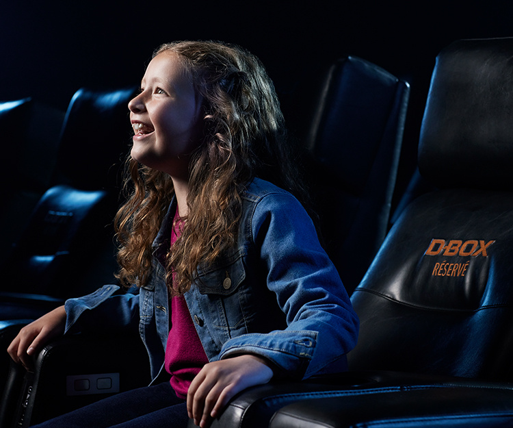 Kids watching a movie in a D-BOX seat