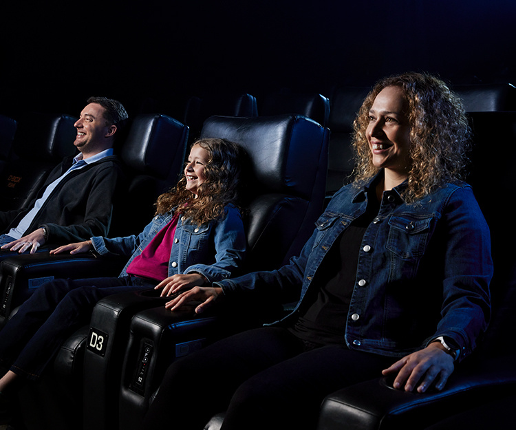 Family watching a movie in a theater in D-BOX seats